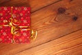 Christmas gift, trendy red present box wrapped with golden ribbon decoration on rustic wooden background. Flatlay style Royalty Free Stock Photo