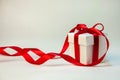 Christmas Gift in White Box with Red Ribbon on Light Background. New Year Holiday Composition. Copy Space Royalty Free Stock Photo