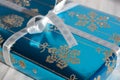 Christmas gift wrapped in blue with silver glitter snowflakes and bow