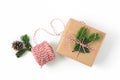 Christmas gift wrapped in craft brown paper and decorated with fir-tree branches isolated on white background. New year gift givin Royalty Free Stock Photo