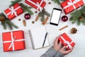 Christmas gift wrapping background, copy space. Woman with red manicure holding in hands red box with white ribbon bow. Royalty Free Stock Photo