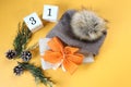 Christmas gift with yellow bows in winter gray hat, numbers three and one on yellow background, top view, space for text