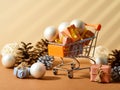 Christmas gifts in a beautiful package in a trolley. Lots of Christmas tree decorations, cones. Sales, discounts, shopping.