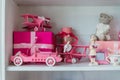 Christmas gifts in box on a shelf, pink car, airplane, wooden horse and gingle bell. Royalty Free Stock Photo