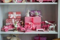 Christmas gifts in box on a shelf, pink car, airplane, wooden horse and gingle bell. Royalty Free Stock Photo