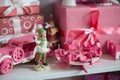 Christmas gifts in box on a shelf, pink car, airplane, wooden horse and gingle bell. Royalty Free Stock Photo