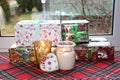 Christmas gifts in boxes and burning candles in glass candlesticks with gingerbread