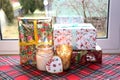 Christmas gifts in boxes and burning candles in glass candlesticks