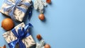 Christmas gifts with bronze balls decorations and fir branches on pastel blue background. Xmas banner design