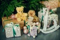 Cute little boy sitting down by the decorated Christmas tree with toys, teddy bears and gift boxes Royalty Free Stock Photo