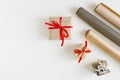 Christmas gifts flat lay: small boxes wrapped in kraft paper and paper rolls on white table Royalty Free Stock Photo