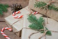 Christmas gifts or gift box wrapped in kraft paper with decorations, pine cones and fir branches on a rustic wooden Royalty Free Stock Photo