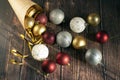 Christmas gifts, gold, silver, red Christmas balls spilled out from a package of kraft paper on a wooden background. Christmas bal Royalty Free Stock Photo