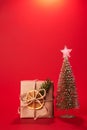 christmas gifts near small christmas tree on red background. Greeting card Royalty Free Stock Photo