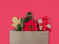 Christmas gifts in paper eco bag on on a red background. Festive flatlay composition. Holiday gift shopping concept. Copy space.