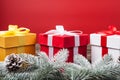 Christmas gifts presents on red background. Snow fir tree white and golden and red gift boxes with ribbon bows and Royalty Free Stock Photo