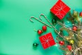 Christmas gifts in red boxes, green and red Christmas balls, candy-canes and Christmas tree branch Royalty Free Stock Photo