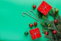 Christmas gifts in red boxes, green and red Christmas balls, candy-canes and Christmas tree branch Royalty Free Stock Photo