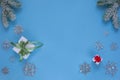 Christmas gifts with ribbons, snowy sprig of pine and decorative snowflakes isolated on blue background. Flat lay Royalty Free Stock Photo