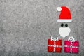 Christmas gifts and Santa Claus on grey background. Royalty Free Stock Photo