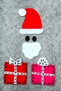 Christmas gifts and Santa Claus on grey background. Royalty Free Stock Photo