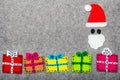 Christmas gifts and Santa Claus on grey background. Royalty Free Stock Photo