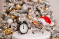 Christmas gifts shopping time. A shopping trolley with a santa hat with a credit card inside and an alarm clock by the Royalty Free Stock Photo