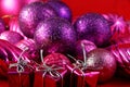 Christmas gifts sit in front of purple Christmas baubles Royalty Free Stock Photo