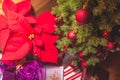Christmas gifts under the tree with balls and red flowers Royalty Free Stock Photo