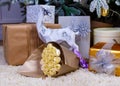 Christmas gifts under the Christmas tree red and wooden toys brick wall, in foreground bouquet of chocolate flowers Royalty Free Stock Photo