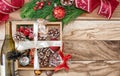 Christmas gifts in a wooden box on a wooden background. Christmas tree branches, decorations, cones, angel, gifts and a bottle Royalty Free Stock Photo