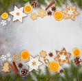 Christmas ginger cookies in the shape snowflakes, dried orange, star anise and fir cones on gray stone background Royalty Free Stock Photo