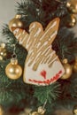 Christmas gingerbread angel on the background of a Christmas tree with golden balls Royalty Free Stock Photo