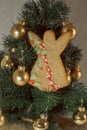 Christmas gingerbread angel with icing. Christmas tree on the background.