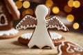 Christmas gingerbread cookie in the form of an angel with a gingerbread house in the background Royalty Free Stock Photo