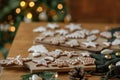 Christmas gingerbread cookies with icing on festive rustic table with decorations against golden tree lights. Merry Christmas! Royalty Free Stock Photo