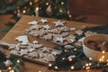 Christmas gingerbread cookies with icing on festive rustic table with decorations against golden tree lights. Merry Christmas! Royalty Free Stock Photo