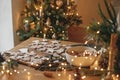 Christmas gingerbread cookies with icing on festive rustic table with decorations against golden tree lights. Merry Christmas! Royalty Free Stock Photo