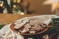 Christmas gingerbread cookies with icing in plate on festive rustic table with decorations against golden illumination. Merry Royalty Free Stock Photo