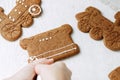 Christmas gingerbread cookies painted with icing sugar. Confectioner girl paints Royalty Free Stock Photo