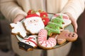 Christmas gingerbread cookies on the plate in the women`s hands Royalty Free Stock Photo