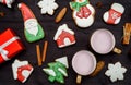 Christmas gingerbread cookies, two cups of hot cocoa, gift box and decorations on dark wooden background, copy space.