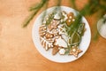 Christmas gingerbread cookies on white plate on wooden background with fir branches Royalty Free Stock Photo