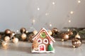 Christmas gingerbread house decoration on background of defocused golden lights. Hand decorated. Shallow DOF Royalty Free Stock Photo