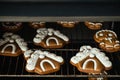 Christmas gingerbread house shaped cookies with white snow icing baking in the oven. Homemade festive traditional gingerbread men Royalty Free Stock Photo