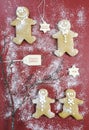 Christmas gingerbread men cookies on dark red wood table. Royalty Free Stock Photo