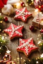 Christmas gingerbread stars, fir branches, red decorations, orange, garland, Santa hat and gift boxes on wooden background. Merry Royalty Free Stock Photo