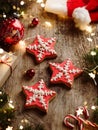 Christmas gingerbread stars, fir branches, red decorations, orange, garland, Santa hat and gift boxes on wooden background. Merry Royalty Free Stock Photo