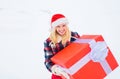 Christmas Girl holding a big gift. Crazy Christmas girl pushes a big gift on snow winter background. Merry Christmas and Royalty Free Stock Photo