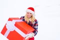 Christmas Girl holding a big gift. Crazy Christmas girl pushes a big gift on snow winter background. Merry Christmas and Royalty Free Stock Photo